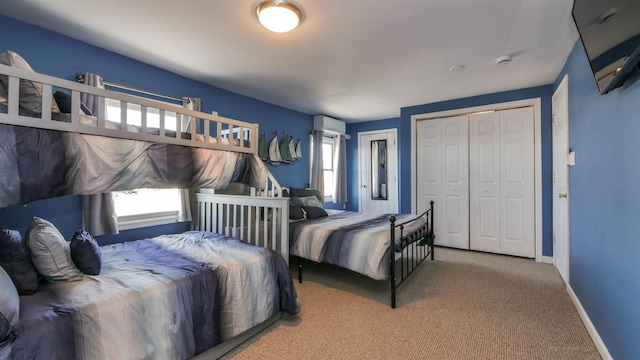 bedroom with carpet, baseboards, a closet, and a wall mounted AC