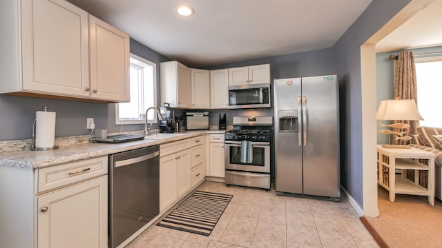 kitchen featuring a sink, light tile patterned floors, recessed lighting, and stainless steel appliances