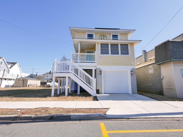 view of front of house with a garage, a porch, concrete driveway, and stairway