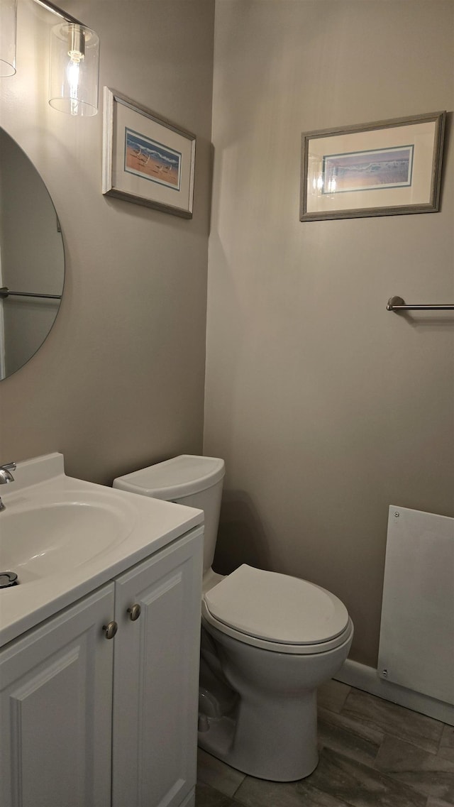 bathroom with vanity, hardwood / wood-style flooring, and toilet