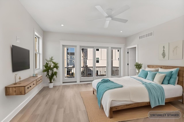 bedroom with access to outside, multiple windows, light wood-type flooring, and baseboards