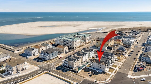 drone / aerial view featuring a view of the beach and a water view