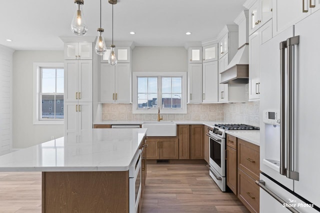 kitchen featuring tasteful backsplash, plenty of natural light, white appliances, and a sink