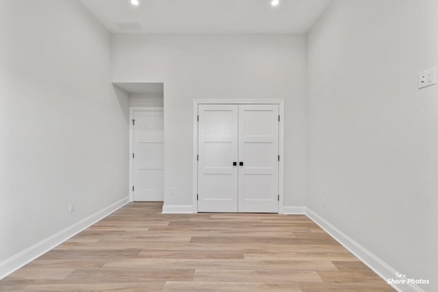 unfurnished bedroom featuring light wood-style flooring, baseboards, and recessed lighting