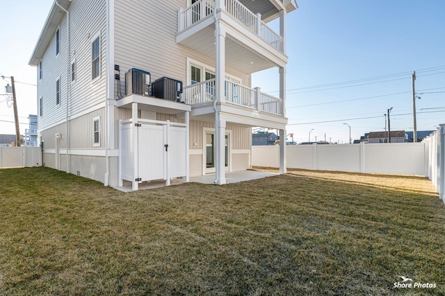 back of property with a fenced backyard, central AC unit, a patio, and a yard