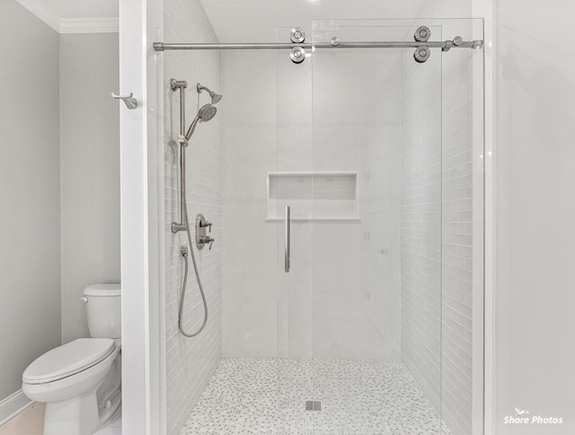 full bath featuring a shower stall, toilet, and crown molding