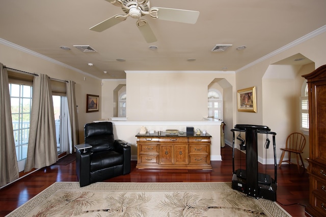 living area with dark hardwood / wood-style flooring, ceiling fan, and crown molding