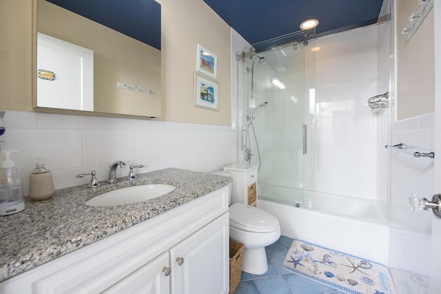 full bathroom with tile patterned floors, vanity, tile walls, and toilet