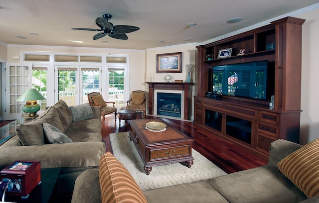 living room featuring crown molding, ceiling fan, and wood-type flooring