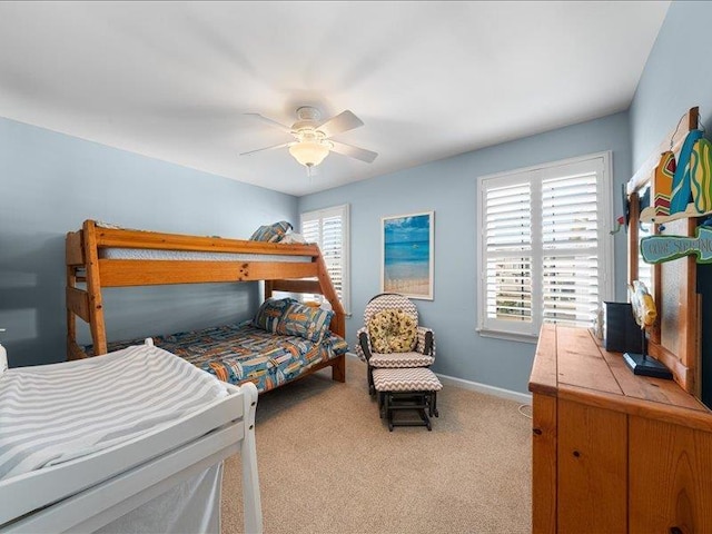 carpeted bedroom with multiple windows and ceiling fan