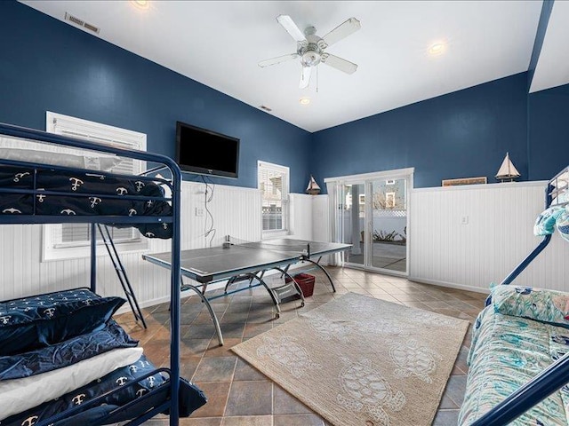 bedroom with ceiling fan and wooden walls