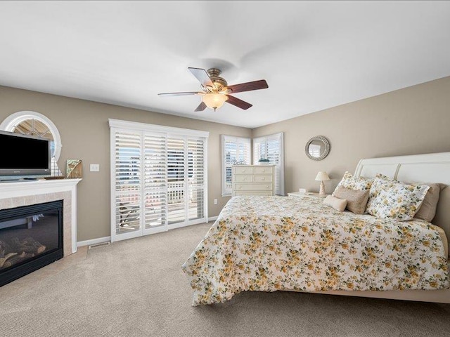 carpeted bedroom featuring ceiling fan, a fireplace, and access to outside