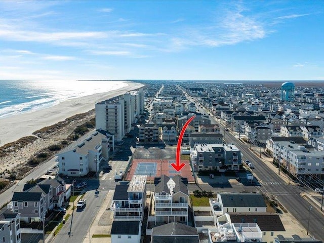 birds eye view of property featuring a water view and a beach view