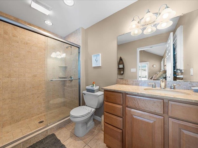 bathroom featuring vanity, a shower with door, tile patterned floors, toilet, and a chandelier