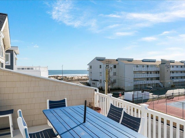 balcony featuring a beach view and a water view