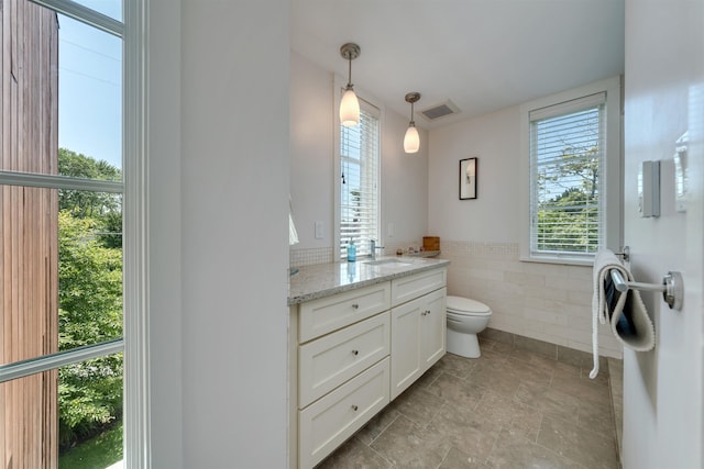 312 S Lake Dr, Cape May Point, NJ 08212 - bathroom featuring tile walls, vanity, plenty of natural light, and a wainscoted wall