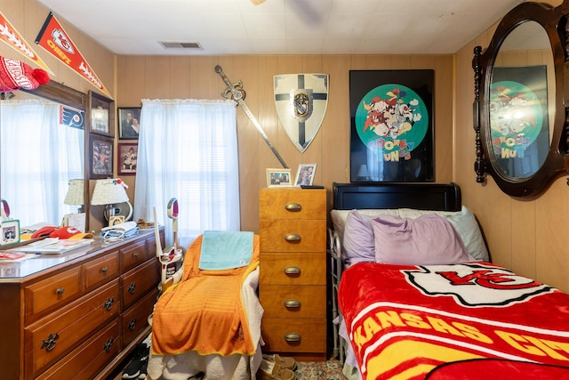 bedroom featuring wood walls