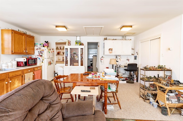 kitchen with white refrigerator, sink, and light carpet