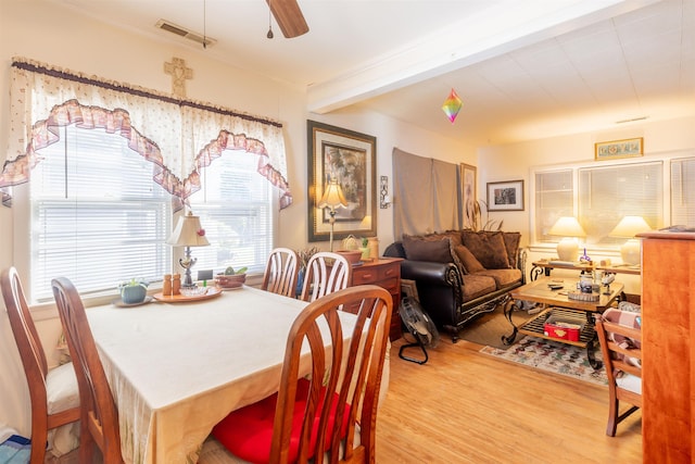 dining area featuring ceiling fan, beamed ceiling, and light hardwood / wood-style floors