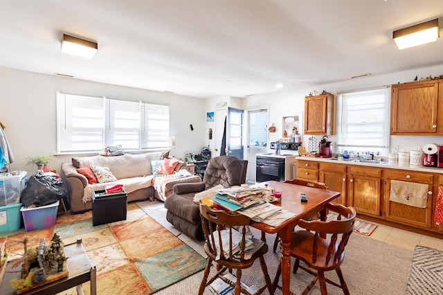 kitchen featuring sink, light tile patterned floors, and white electric range oven