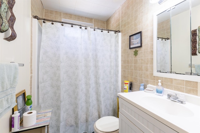 bathroom featuring vanity, toilet, decorative backsplash, and tile walls