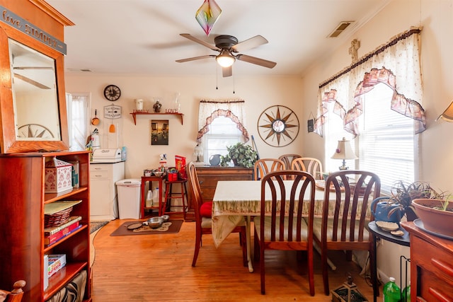 dining space with ceiling fan, light hardwood / wood-style floors, crown molding, and a wealth of natural light