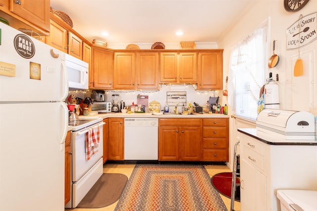 kitchen featuring white appliances, a wealth of natural light, ornamental molding, and sink