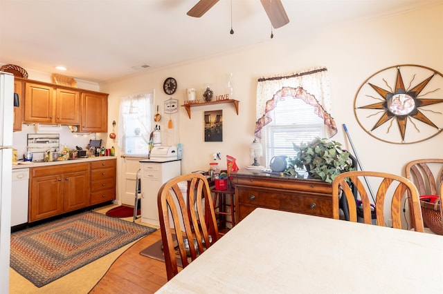 dining space with light hardwood / wood-style flooring, ceiling fan, crown molding, and sink