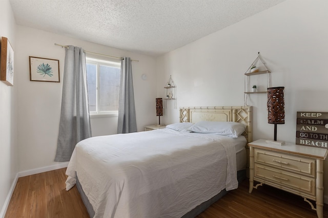 bedroom featuring a textured ceiling and dark wood-type flooring