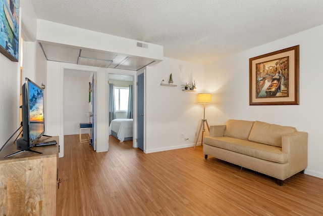 sitting room with hardwood / wood-style floors and a textured ceiling