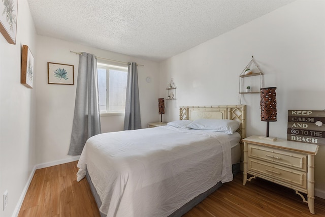 bedroom with wood-type flooring and a textured ceiling