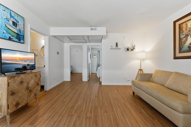 living room featuring wood-type flooring and a textured ceiling