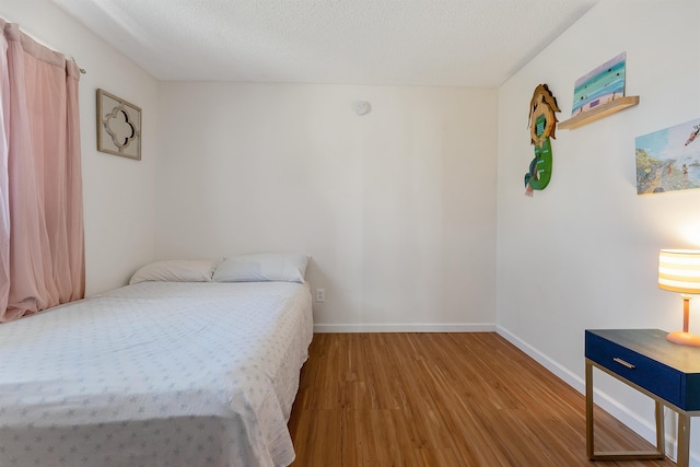 bedroom featuring hardwood / wood-style flooring and a textured ceiling