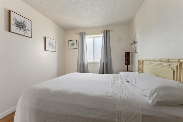 bedroom with hardwood / wood-style floors and a textured ceiling