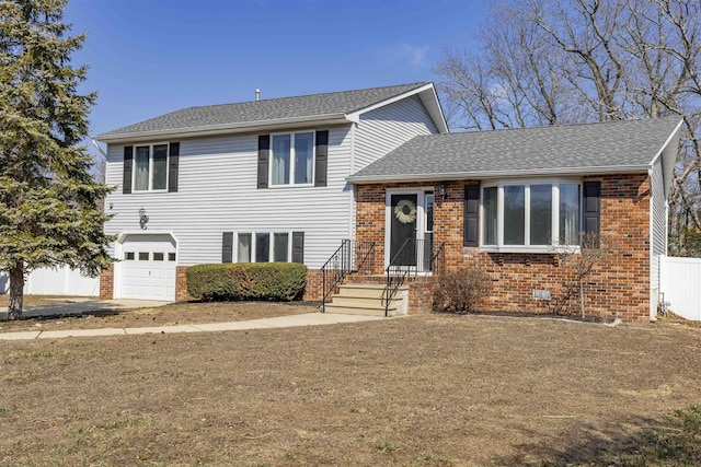 split level home featuring crawl space, brick siding, roof with shingles, and a garage