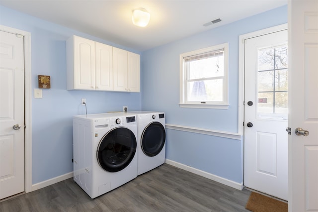 washroom featuring washing machine and clothes dryer, cabinet space, dark wood finished floors, and baseboards