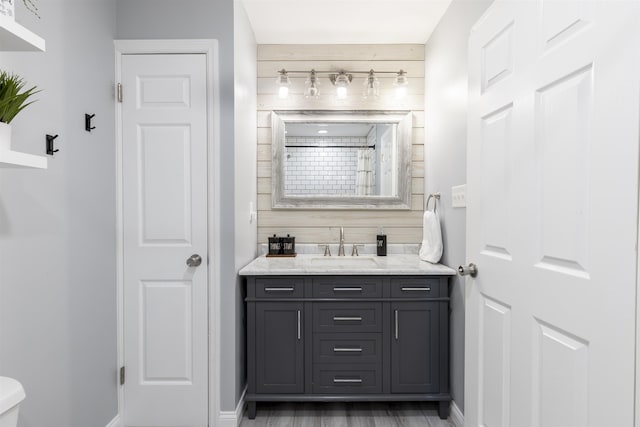 bathroom with a shower, baseboards, toilet, and vanity