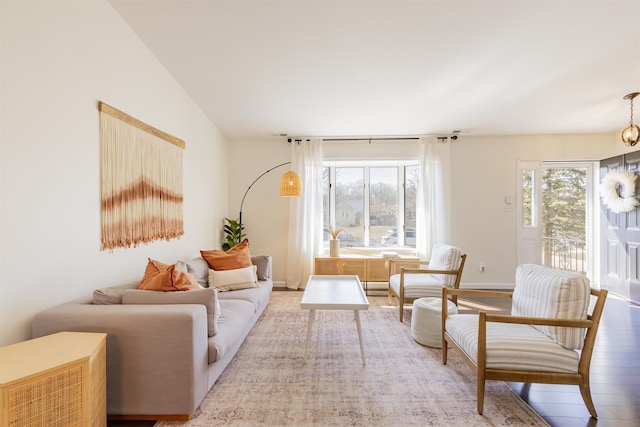 living room with vaulted ceiling, baseboards, and wood finished floors