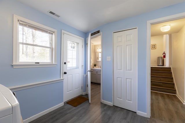 entryway featuring dark wood finished floors, visible vents, stairway, and baseboards