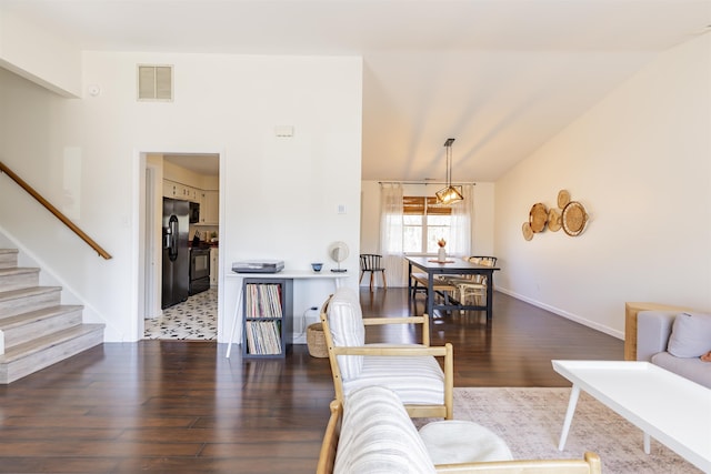 living room featuring wood finished floors, visible vents, baseboards, lofted ceiling, and stairs