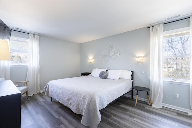 bedroom featuring multiple windows, baseboards, and dark wood-style flooring