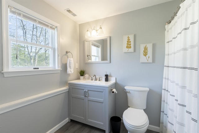 bathroom featuring visible vents, toilet, wood finished floors, baseboards, and vanity