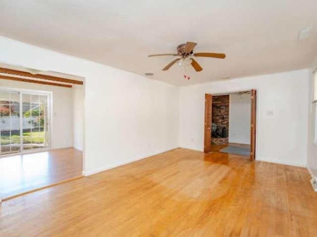 unfurnished living room with ceiling fan, wood-type flooring, and a brick fireplace