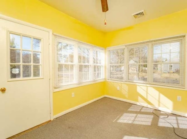 unfurnished sunroom with a healthy amount of sunlight and ceiling fan