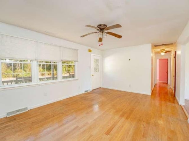 empty room with light hardwood / wood-style flooring and ceiling fan