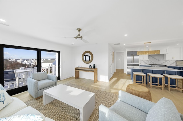 living room featuring light wood-type flooring and ceiling fan