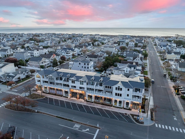 aerial view at dusk featuring a water view