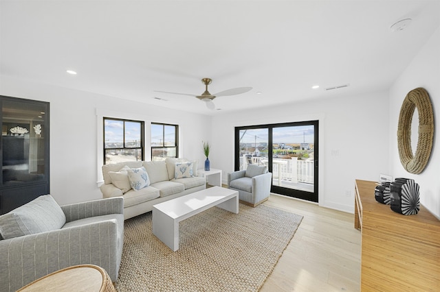 living room with ceiling fan, light hardwood / wood-style floors, and a healthy amount of sunlight