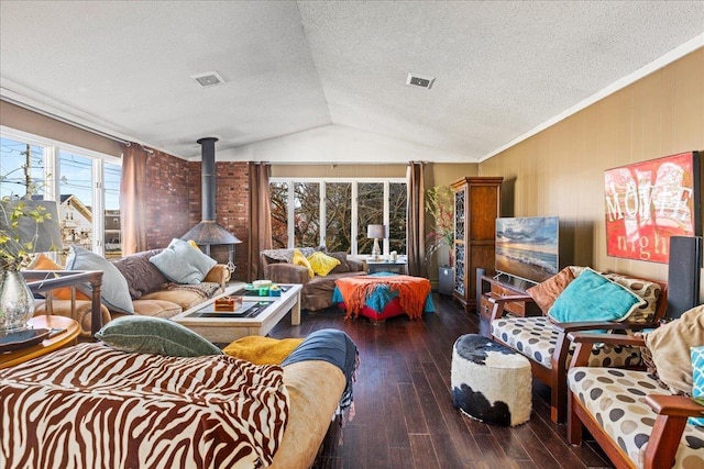 living room featuring a textured ceiling, a wood stove, lofted ceiling, and dark hardwood / wood-style floors