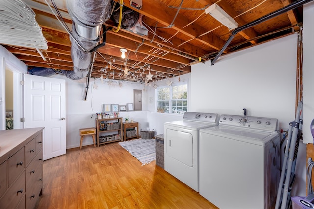 laundry room with light hardwood / wood-style floors and washing machine and clothes dryer